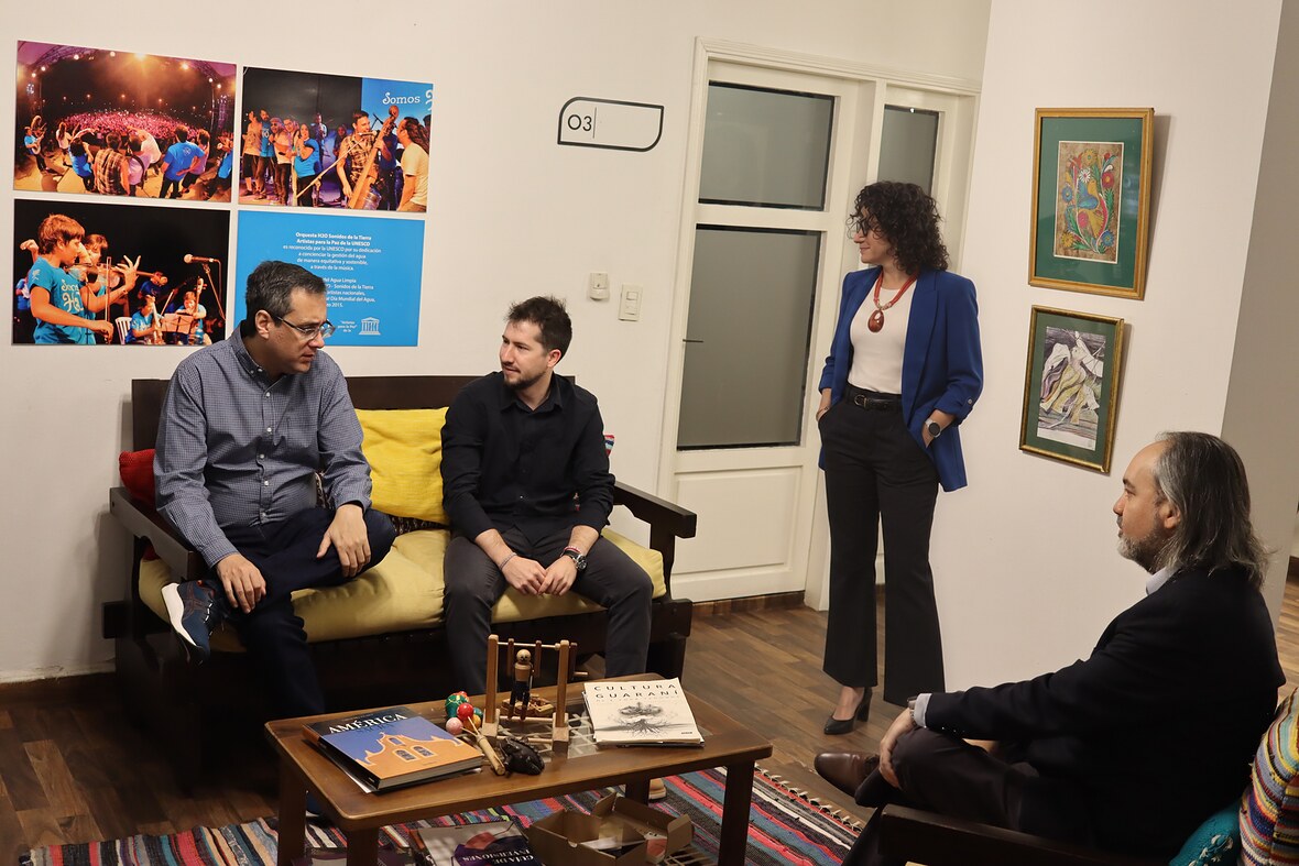 Cuatro integrantes de INDEX conversan en la sala de sofás de la sede; una de ellas, de pie