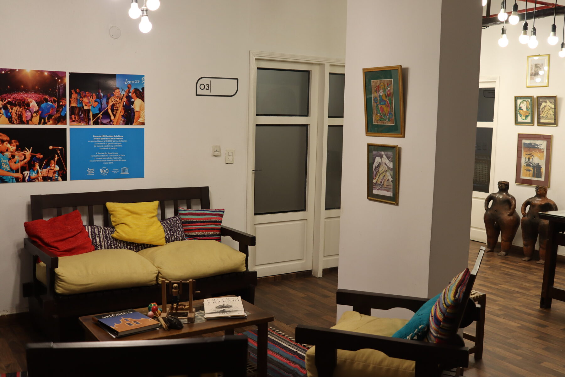 Sala de estar de la sede con el sofá y, al fondo, las figuras de cerámica y los cuadros